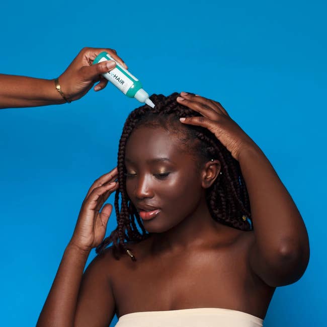 model applying the treatment to their scalp