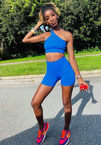 Reviewer in blue bike shorts with matching blue one-shoulder cropped tank top 
