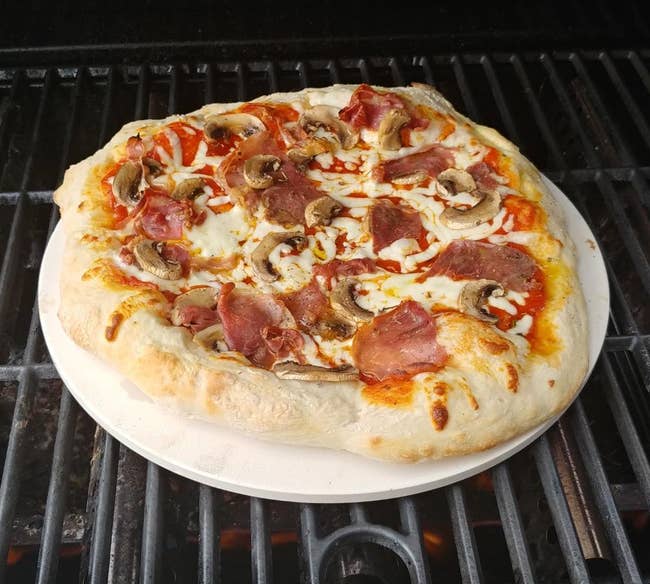 reviewer photo of a cooked pizza on the pizza stone on a grill