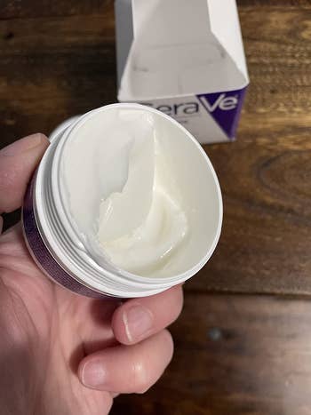 image of open container of night cream in a reviewer's hand