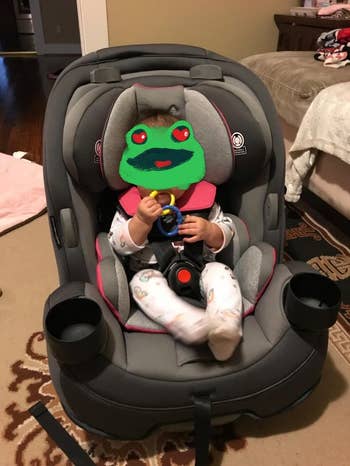 Baby successful  a car   spot   holding a toy, dressed successful  patterned pajamas. The mounting  is simply a cozy country   with a disposable   furniture  and carpet