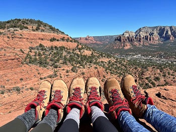 reviewer photo, three people wearing Columbia hiking boots with red laces, over Grand Canyon