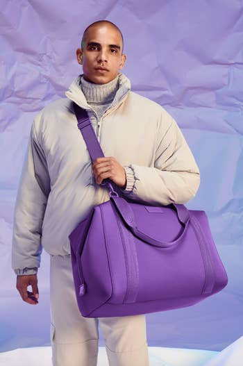 model wearing the duffle bag in purple