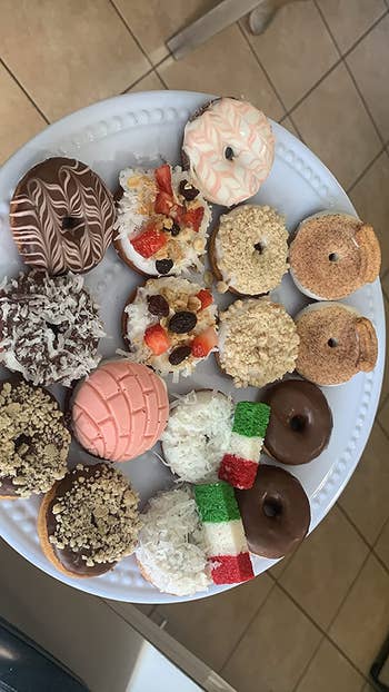 A plate filled with mini donuts with various toppings 
