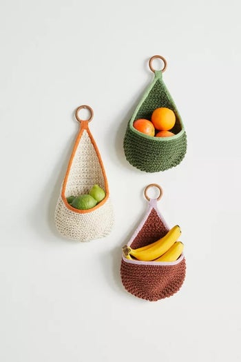 Three fruit bags that are hanging on a wall