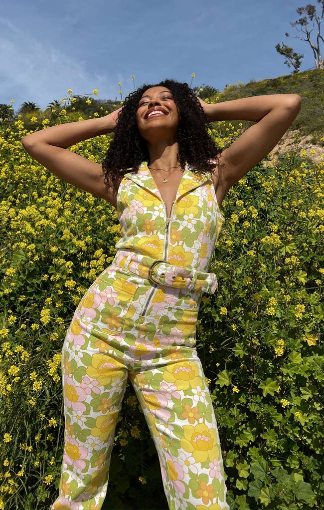 A model posing in the pink and yellow floral jumpsuit