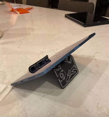 The holder folded to prop up a tablet on a counter 