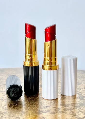 Two red lipstick shaped lighters in black and white 