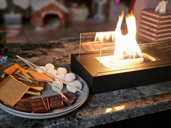 reviewers lit fire pit with plate of s'mores ingredients