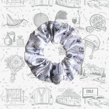 A white and gray scrunchie with folklore-themed patterns on it from Taylor Swift 