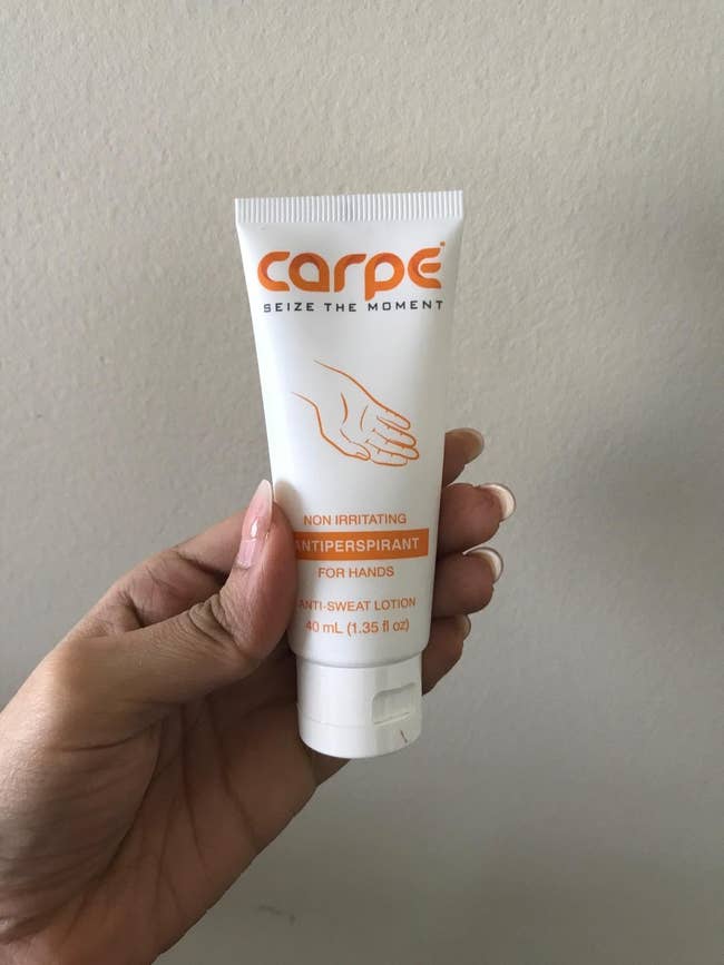 image of reviewer holding up the tube of hand cream