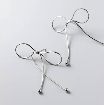 a pair of silver ribbon earrings