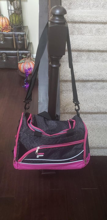 reviewer photo of black and pink Fila bag hanging on stairwell