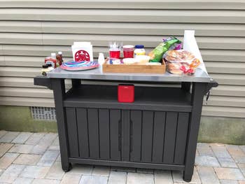 reviewer's cart with paper plates, napkins, cups, condiments, and other food and party supplies on it