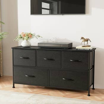 the five drawer fabric dresser with decor on top of it