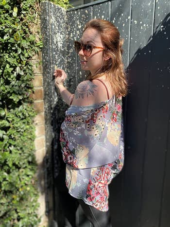 another reviewer wearing purple-blue cardigan with yellow, white, and pinkish  florals connected  it