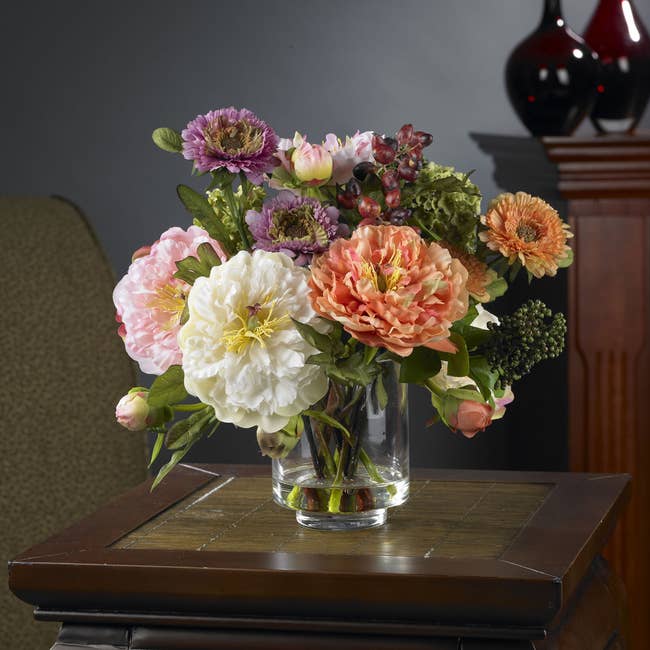 a glass vase of brightly colored peonies