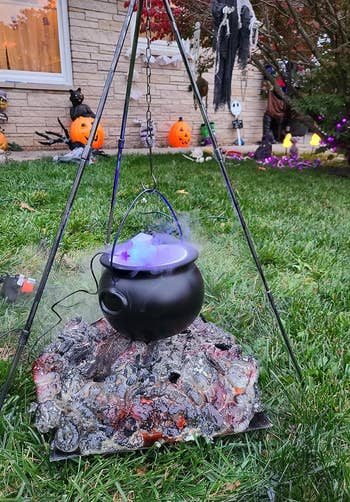 a reviewer's cauldron set up in a front yard with smoke coming out