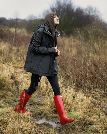 model wearing tall red Hunter rain boots