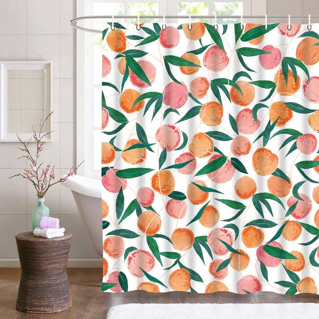 the peach print shower curtain hanging in a bathroom