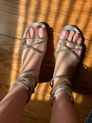 reviewer wearing the gold strappy sandals