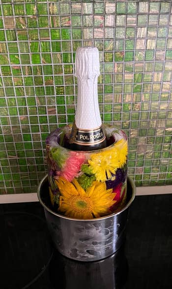 Champagne vessel successful an crystal bucket decorated with embedded flowers, connected a tiled surface