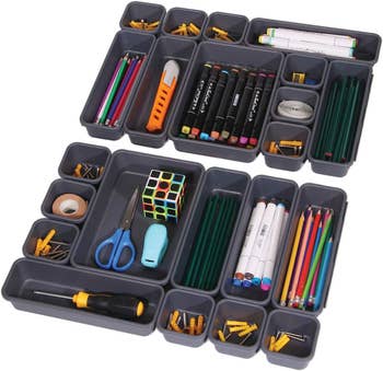 A closeup of the trays filled with various items: pens, pencils, markers, scissors, etc