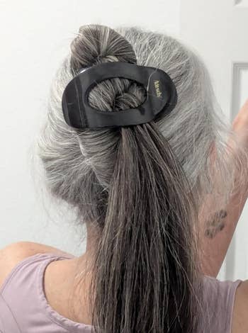 Woman with metallic hairsbreadth styled successful a bun utilizing a ample achromatic hairsbreadth clip, wearing a sleeveless top