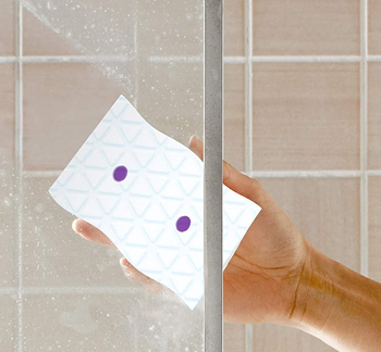 Model using product to wipe shower door