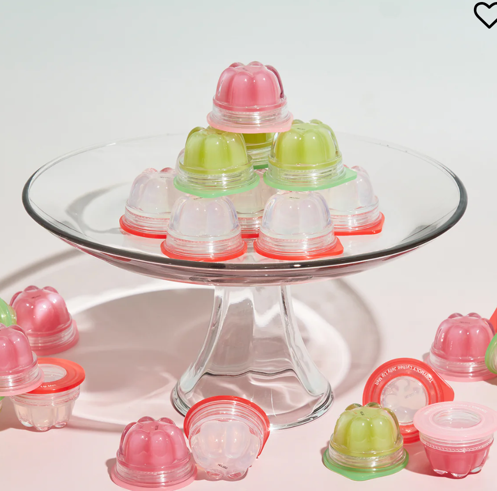Small containers of lip jelly in green, pink, and clear colors 