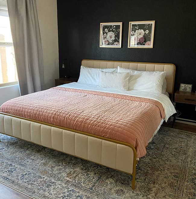 A well-made bed with a white duvet and pink throw in a bedroom for a shopping article on home decor