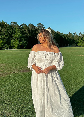 a reviewer in whitte with the sleeves off shoulder