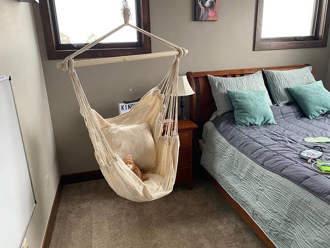 a reviewer photo with the hammock in ivory hanging next to their bed