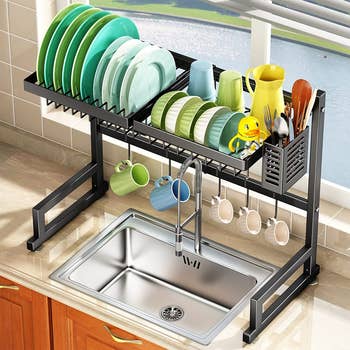 the black rack placed over a sink with dishes drying in it