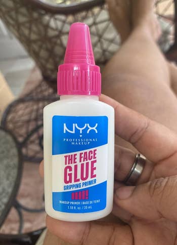 Hand holding a vessel  of NYX Professional Makeup 