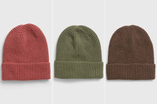 Waffle knit beanies in coral, green, and brown on a gray background