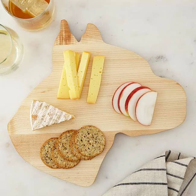 Dog-shaped cheese board with food sprawled on it