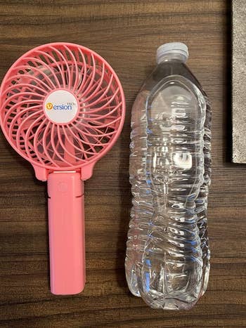 Fan next to a water bottle to show size 