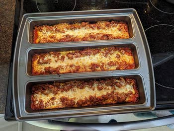 The pan filled with lasagna in the three sections 