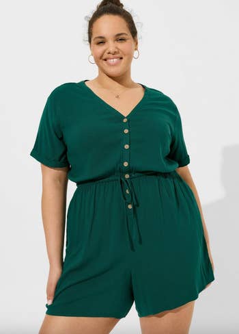 model in a short-sleeved green button-up romper with shorts 