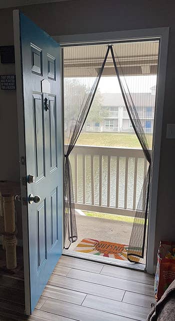 a reviewer photo of the installed mesh door pulled back on each side like curtains 
