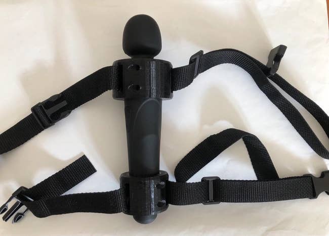Black wand vibrator in black strap holders with straps