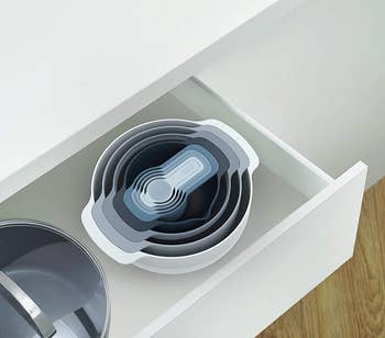 the bowls and measuring cups nested and neatly stored in a kitchen drawer