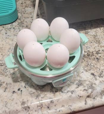 Egg cooker containing six eggs connected a countertop