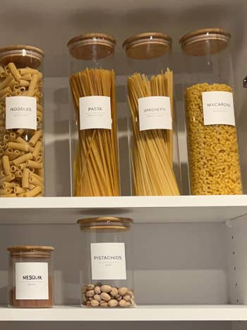 Organized pantry with labeled containers for noodles, pasta, spaghetti, macaroni, and pistachios