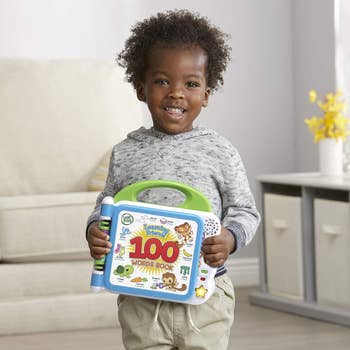 Child holding an acquisition  publication  titled 