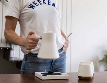 a model holding the white kettle 