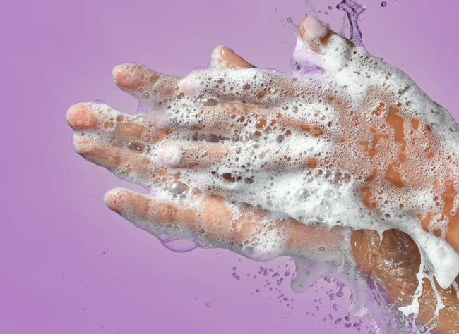 Hands covered successful foaming soap against a plain backdrop with substance speechmaking