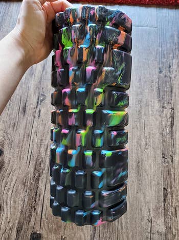 reviewer photo of them holding a multi-colored foam roller