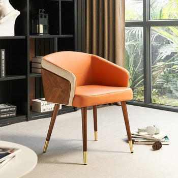 an orange upholstered chair with wood herringbone siding